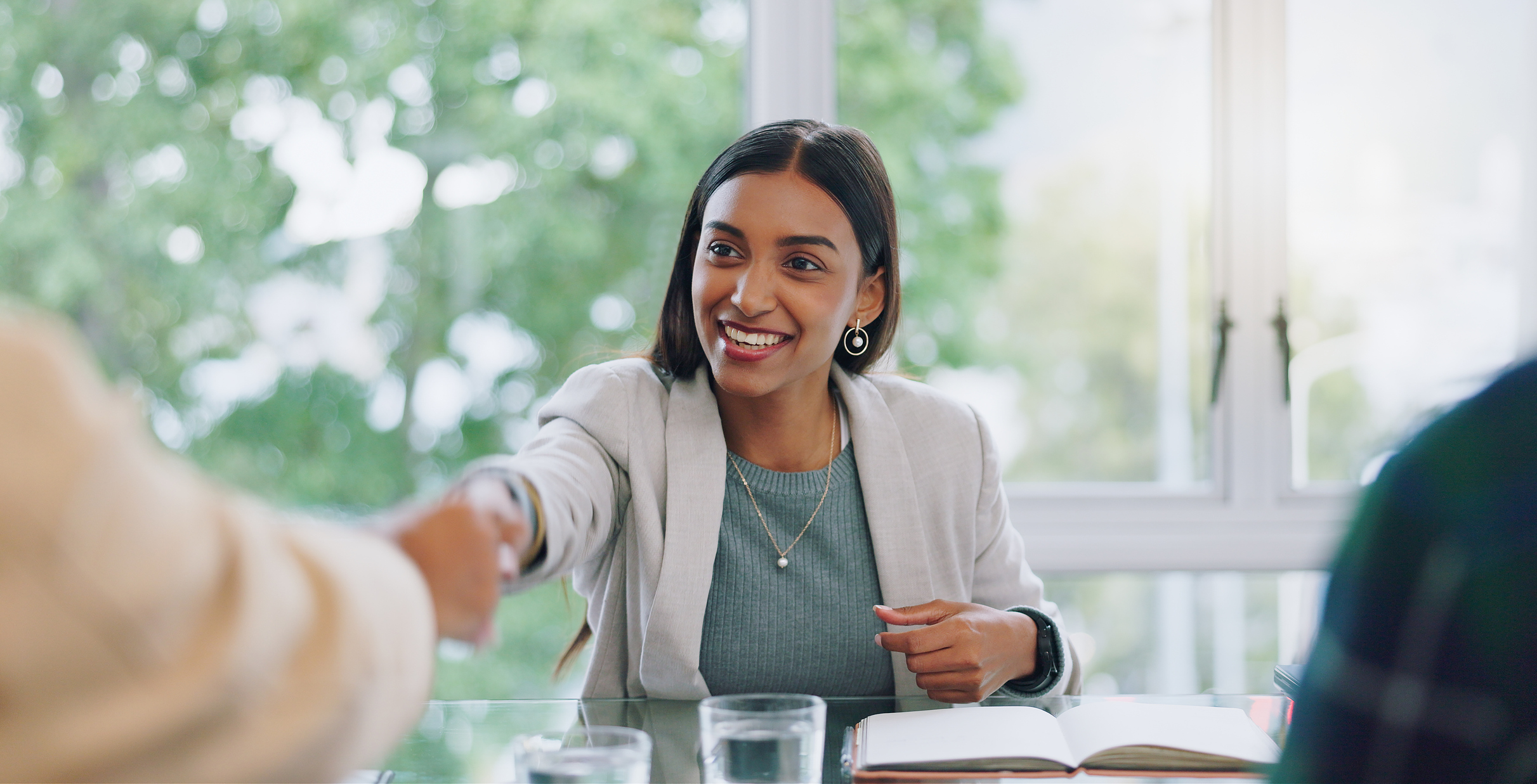 Een professional begroet haar gesprekspartner tijdens een sollicitatiegesprek